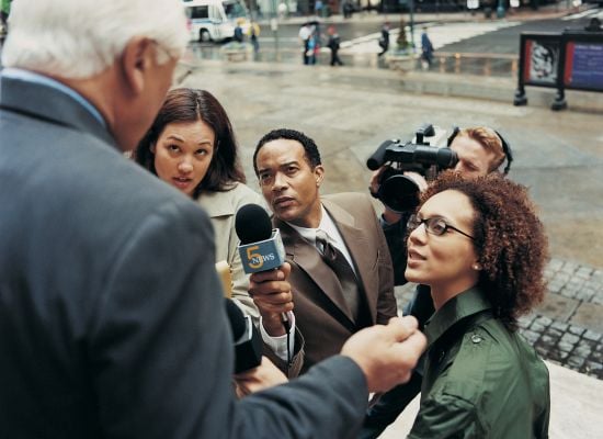 reporters and camera person interviewing someone outside