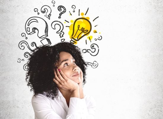 woman on white background with light bulb and question marks drawn above her head